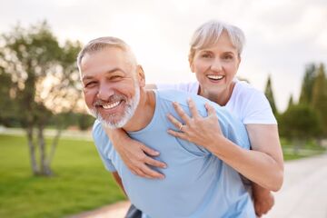 woman piggybacking on man smiling with great teeth