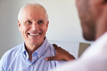man with hand on shoulder being reassured