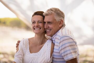 man and woman smiling showing veneers