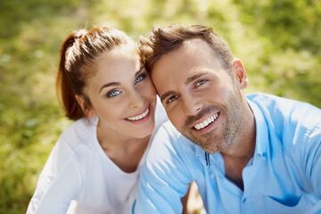 man and woman smiling showing teeth