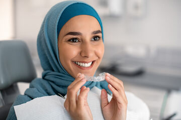woman smiling holding invisalign