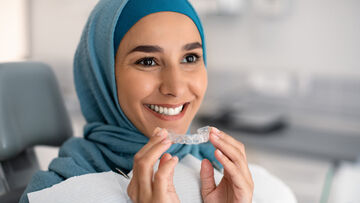 woman smiling holding invisalign