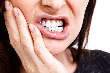 woman holding face in pain