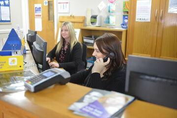 two female receptionists on phone smiling