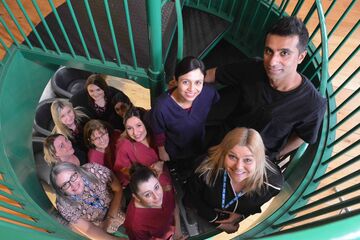 Bhandal dental team standing on stairs