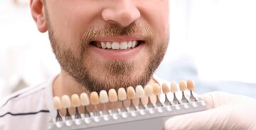 man comparing different teeth whiteness